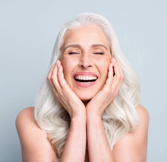 Close-up portrait of her she nice attractive excited cheerful grey-haired elderly lady touching cheeks laughing isolated gray pastel color background.